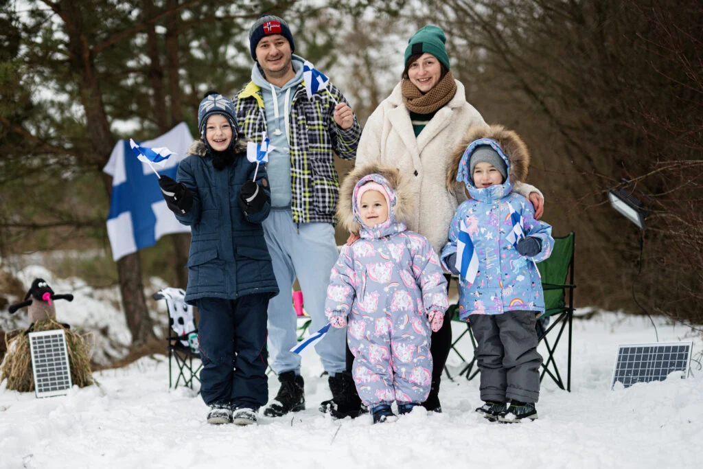 Finnish family with Finland flags on a nice winter day. Nordic S