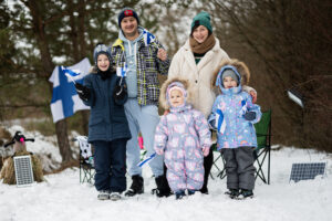 Finnish family with Finland flags on a nice winter day. Nordic S Finnish family with Finland flags on a nice winter day. Nordic S