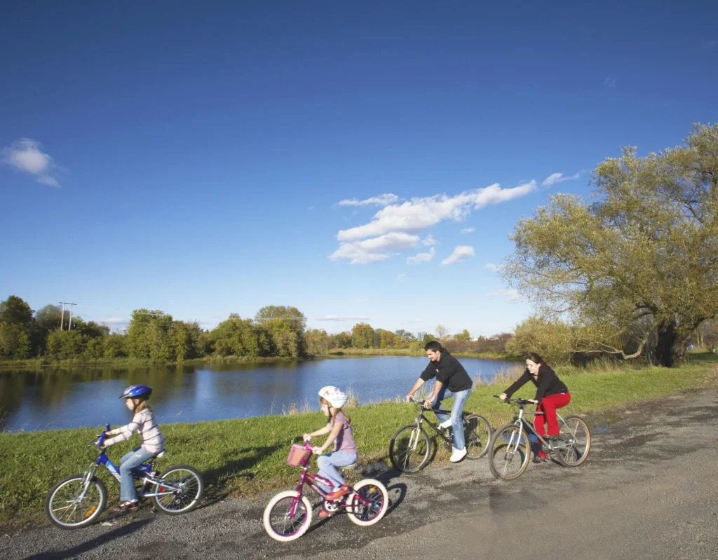 Family cycling along a pond trail near Half Moon Bay in Barrhaven Ottawa