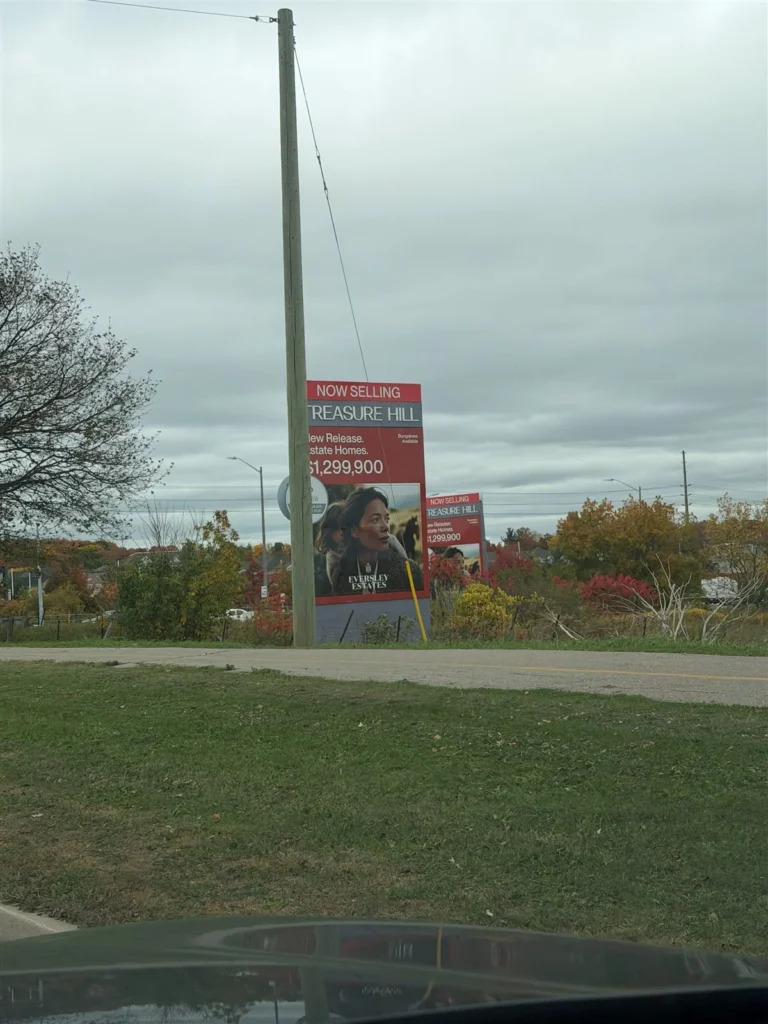 Two Treasure Hill Eversley Estates signs beside the road showing new release estate homes at $1,299,900