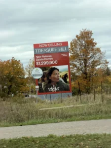 Treasure Hill roadside sign for Eversley Estates in King City advertising new release estate homes at $1,299,900 with bungalows available